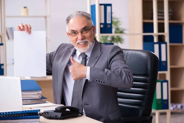 Gammal manlig anställd och pappersarbete på kontoret — Stockfoto