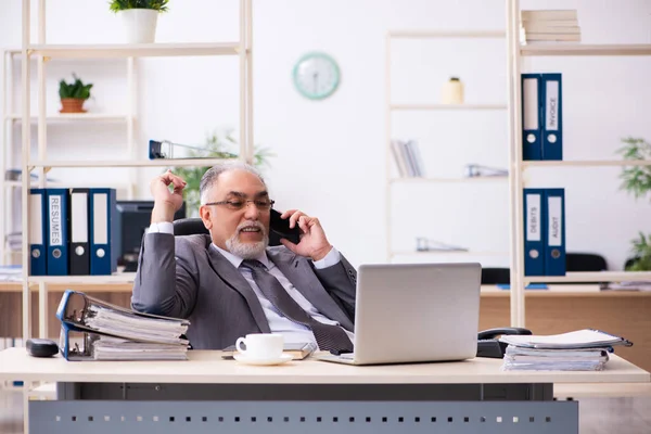 Ancien employé masculin utilisant le téléphone dans le bureau — Photo