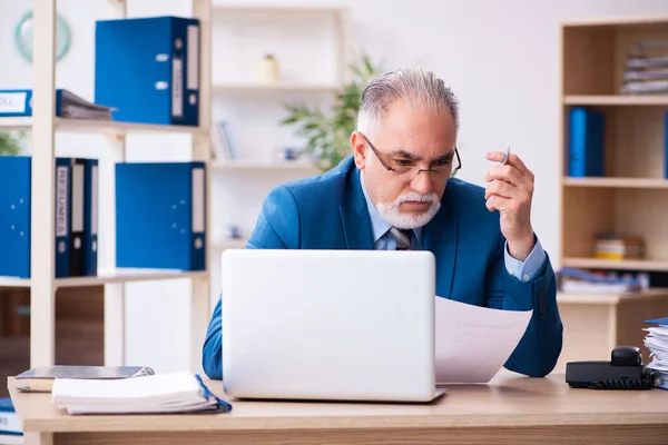 Vecchio contabile maschio infelice con il lavoro eccessivo sul posto di lavoro — Foto Stock