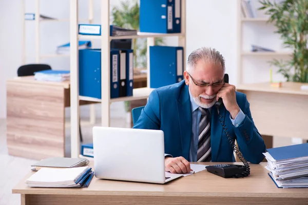 Velho contador masculino infeliz com excesso de trabalho no local de trabalho — Fotografia de Stock