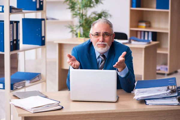 Old male bookkeeper unhappy with excessive work at workplace — Stock Photo, Image