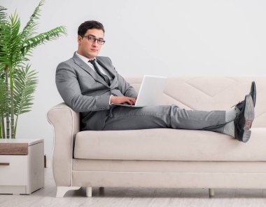 Genç işadamı kanepede yatıyor.