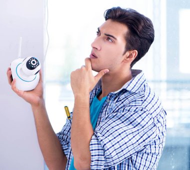 Adam eve güvenlik kameraları yerleştiriyor.