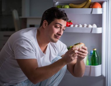 Buzdolabındaki adam gece yemek yiyor.