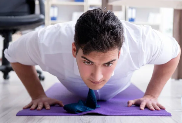 Uomo d'affari che fa sport nel suo ufficio — Foto Stock