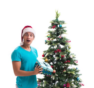 Genç adam beyaz üzerine izole edilmiş noel ağacını süslüyor.