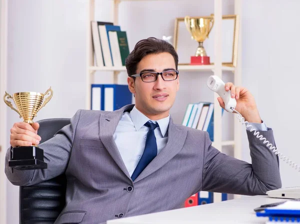 Businessman with prize cup for achievements in office — Stock Photo, Image