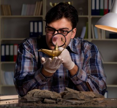 Arkeolog geç saatlere kadar ofiste çalışıyor.