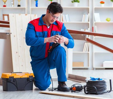 Genç marangoz ahşap kalaslarla çalışıyor.