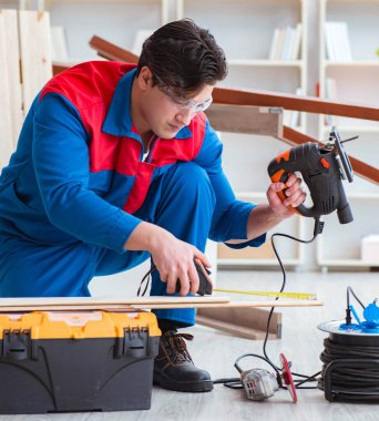 Genç marangoz ahşap kalaslarla çalışıyor.