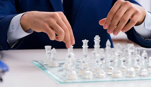 Young businessman playing glass chess in office — Stock Photo, Image