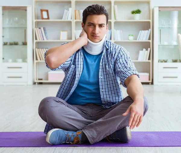 Uomo con lesioni al collo meditando a casa sul pavimento — Foto Stock