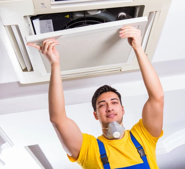 Repairman repairing ceiling air conditioning unit — Stock Photo, Image