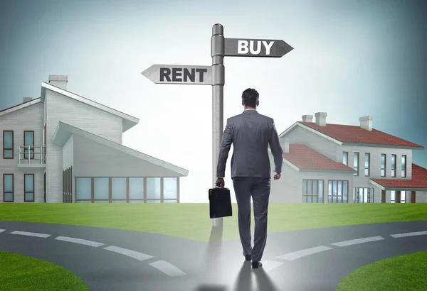 Businessman at crossroads betweem buying and renting — Stock Photo, Image