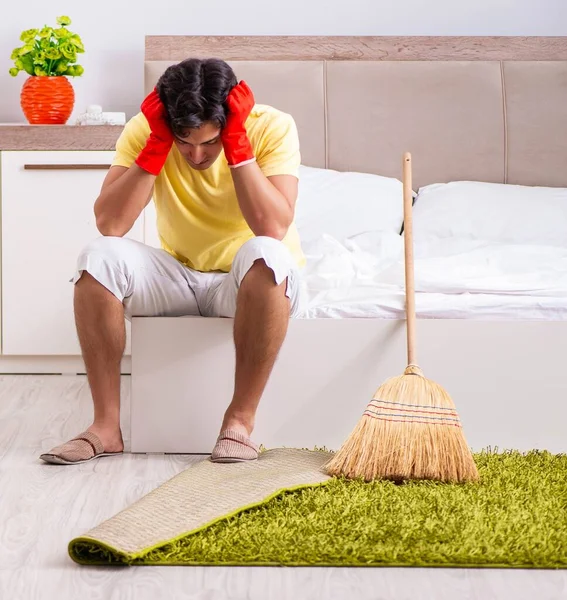 Pemuda tampan membersihkan di kamar tidur — Stok Foto