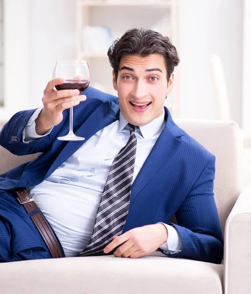 Businessman drinking wine sitting at home — Stock Photo, Image