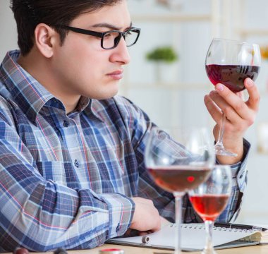 Profesyonel şarap garsonu kırmızı şarap tadıyor.