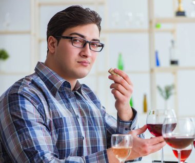 Profesyonel şarap garsonu kırmızı şarap tadıyor.