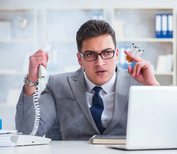 Geschäftsmann raucht im Büro bei der Arbeit — Stockfoto