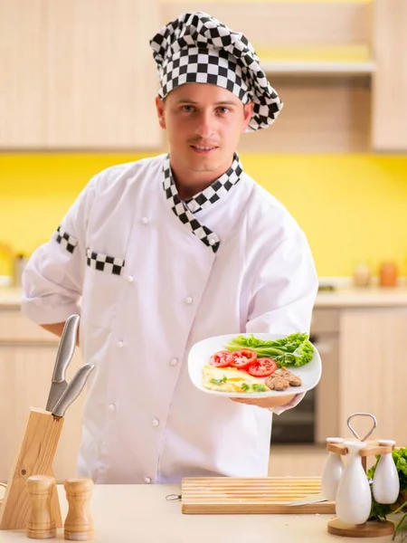 Joven cocinero profesional preparando ensalada en la cocina —  Fotos de Stock