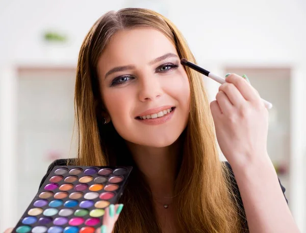 Młoda kobieta stosująca makijaż przygotowująca się do imprezy — Zdjęcie stockowe