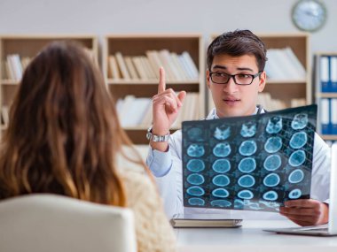 Genç doktor bilgisayardaki röntgen görüntülerine bakıyor.