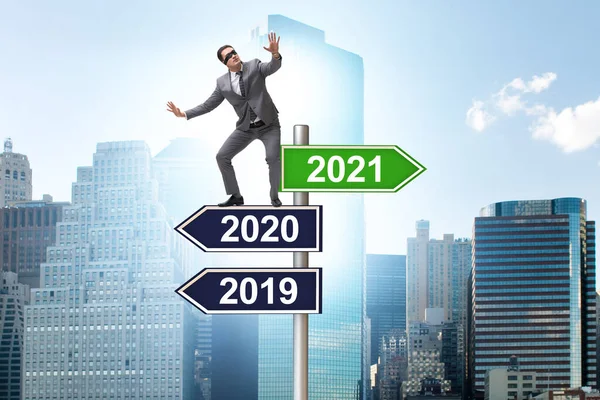 Road sign and businessman with 2020 and 2021 — Stock Photo, Image