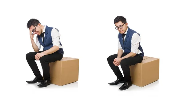 Jovem funcionário sentado na caixa isolado em branco — Fotografia de Stock