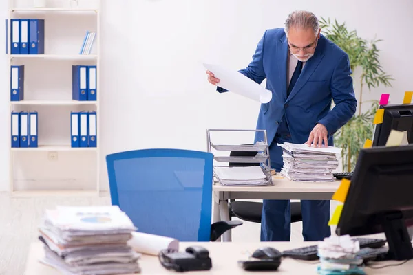 Old male employee and too much work in the office — Stock Photo, Image