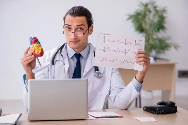 Jovem médico cardiologista procurando eletrocardiograma — Fotografia de Stock