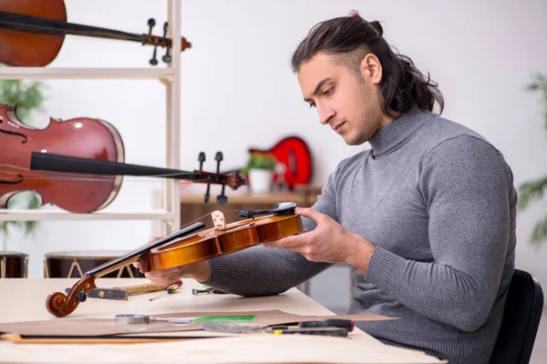 Hombre joven reparador reparando violín —  Fotos de Stock