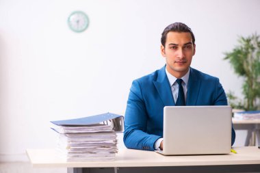 Genç işadamı ofiste oturuyor.