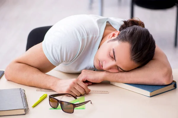 Ung manlig student förbereder sig för tentamen i klassrummet — Stockfoto