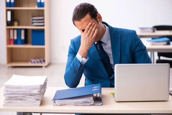 Joven empleado masculino descontento con el trabajo excesivo en la oficina —  Fotos de Stock