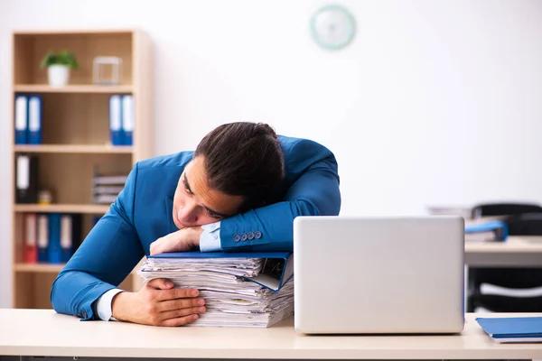 Jovem funcionário masculino infeliz com excesso de trabalho no escritório — Fotografia de Stock