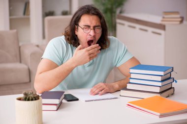 Evde sınava hazırlanan genç bir erkek öğrenci.