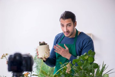 Evin içinde bitkileri olan genç bir erkek bahçıvan.