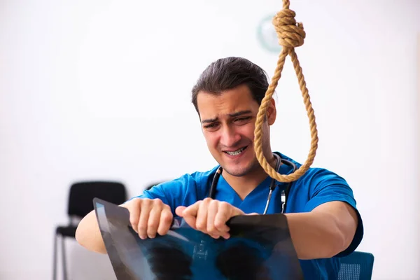 Young male doctor committing suicide at workplace — Stock Photo, Image