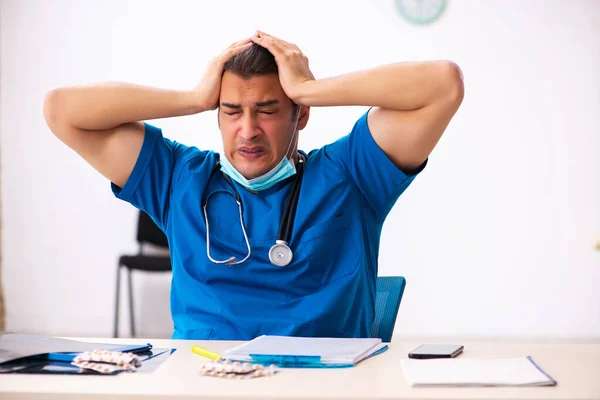 Young male doctor committing suicide at workplace — Stock Photo, Image