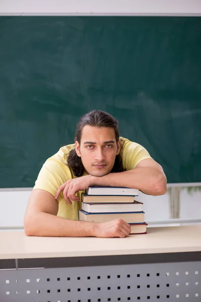 Jovem estudante se preparando para exames em sala de aula — Fotografia de Stock