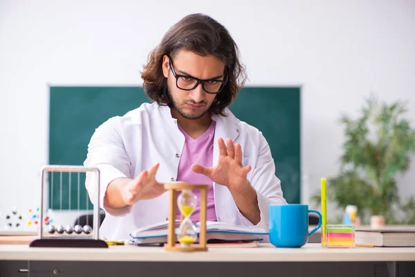 Giovane insegnante di fisica maschile nel concetto di gestione del tempo — Foto Stock