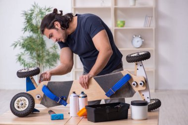 Kaykay tamir eden genç bir erkek tamirci.