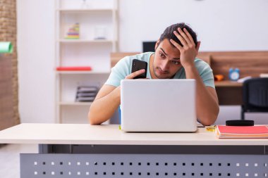 Tele-eğitimde sınavlara hazırlanan genç bir erkek öğrenci