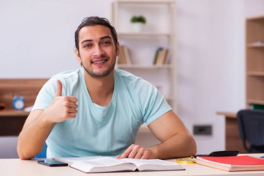 Genç erkek öğrenci sınava evde hazırlanıyor.