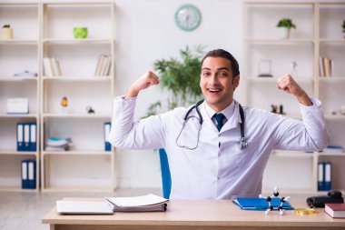 Klinikte çalışan genç erkek doktor.