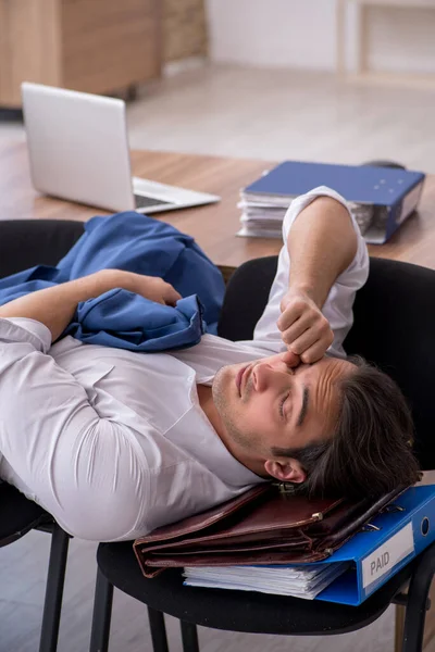 Joven empleado masculino durmiendo en la oficina en sillas — Foto de Stock