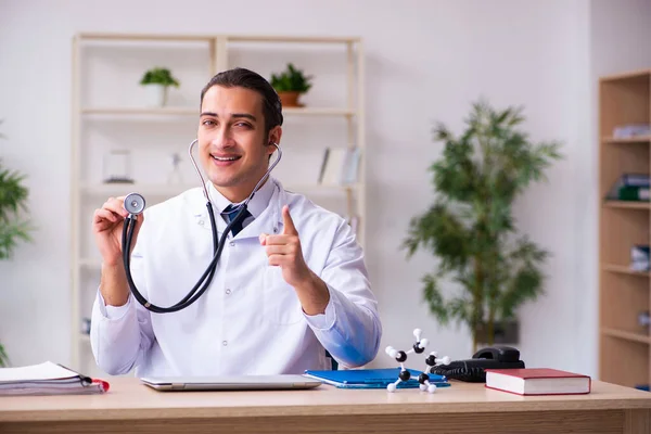 Jonge mannelijke arts met stethoscoop in de kliniek — Stockfoto