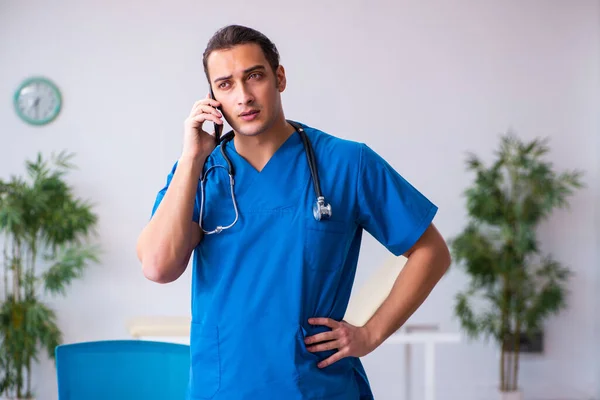 在远程医疗概念中使用智能手机的年轻男医生 — 图库照片