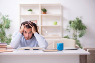 Evde sınava hazırlanan genç bir erkek öğrenci.