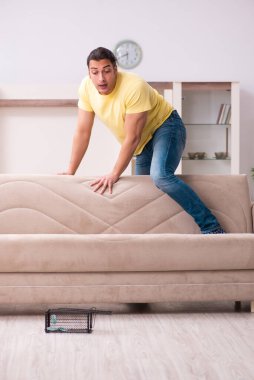 Genç adam ve fare kapanı evde.